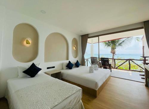 two beds in a room with a view of the ocean at Big Fish Resort Koh Tao in Ko Tao