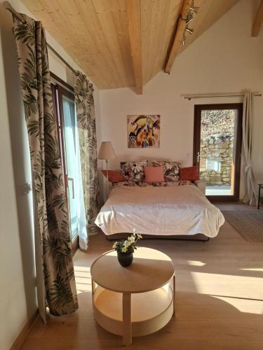 a bedroom with a bed and a table in a room at Chalet du Mont Granier in Apremont