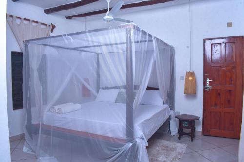 a bed with a canopy in a room at Horizon Bavaria Villa in Mtwapa
