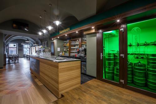 a bar in a restaurant with green lighting at Hotel Concertino Zlatá Husa in Jindrichuv Hradec