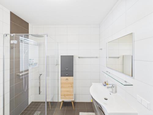 a white bathroom with a sink and a shower at LakeSide Suite in Seeboden
