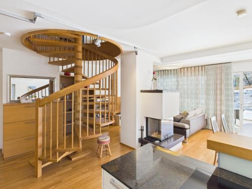 a kitchen and living room with a spiral staircase at LakeSide Suite in Seeboden
