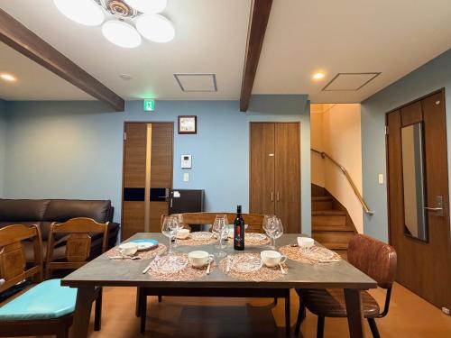 a dining room table with a bottle of wine on it at 熊本熊猫基地 新町 Kumamoto Panda Base Shinmachi in Kumamoto