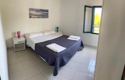 a bedroom with a bed with two towels on it at Residence Nido Verde in Peschici