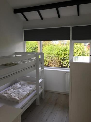 a bedroom with a bunk bed and a window at Spacious 6p vacation home with garden in Zoutelande