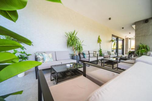 a living room with couches and tables and plants at Hotel Crystal in Orebić