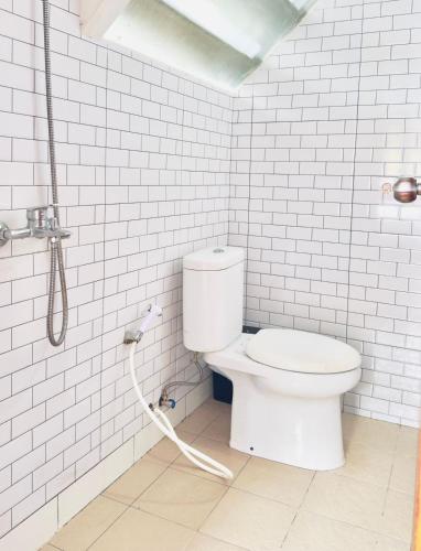 a white bathroom with a toilet and a shower at 5BR Villa with Private Pool Lembang in Bandung