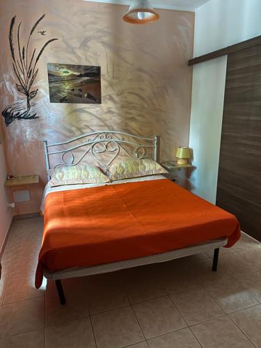 a bedroom with a bed with an orange blanket at B&B Angolo Magico in Baia Di Gallipoli