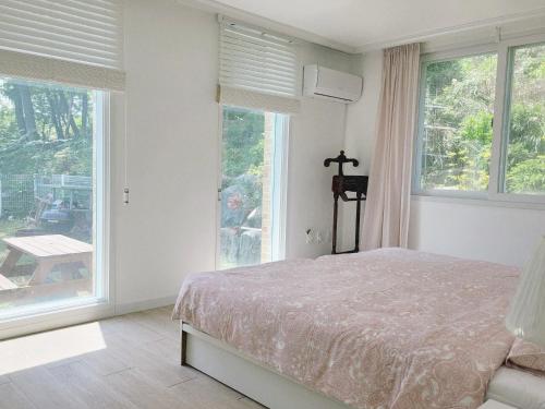a bedroom with a bed and large windows at 대전 SJ Haus in Daejeon
