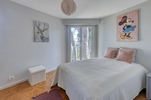 a bedroom with a white bed and a window at Maison Gecko - Proche de la plage in Cavalaire-sur-Mer