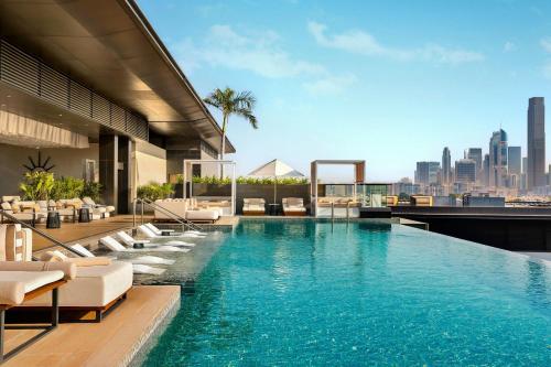 a pool on top of a building with a city skyline at La Ville Hotel & Suites CITY WALK Dubai, Autograph Collection in Dubai
