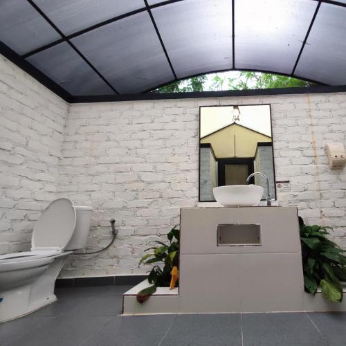 a bathroom with a toilet and a sink at "D'BAMBOO KAMP" Desa Wisata Ekang in Lagoi