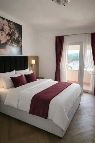 a bedroom with a large white bed with red pillows at Sto Rija in Krk