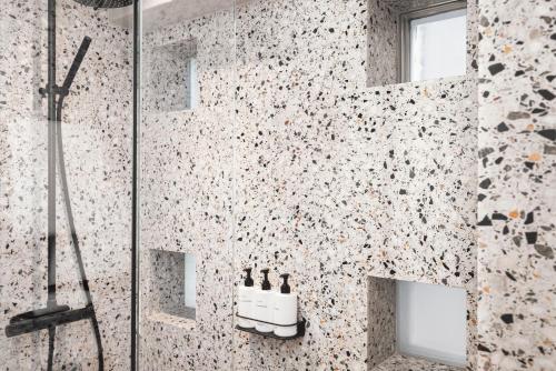 a bathroom with a shower with a sink at Blique by Nobis, Stockholm, a Member of Design Hotels in Stockholm
