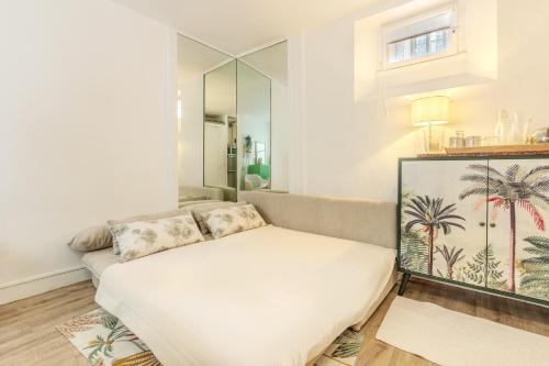 a living room with a couch and a mirror at Studio Cosy - Le Marais centre in Paris