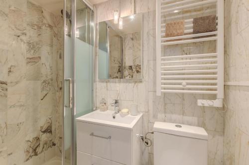 a bathroom with a toilet and a sink and a shower at Studio Cosy - Le Marais centre in Paris
