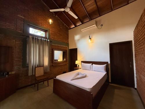 a bedroom with a large bed and a window at Ranmin Lake Weerawila in Weerawila