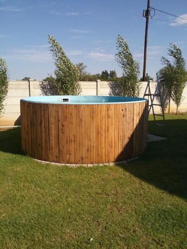 a pool in a yard with a wooden fence at Sevens Guesthouse in Kroonstad
