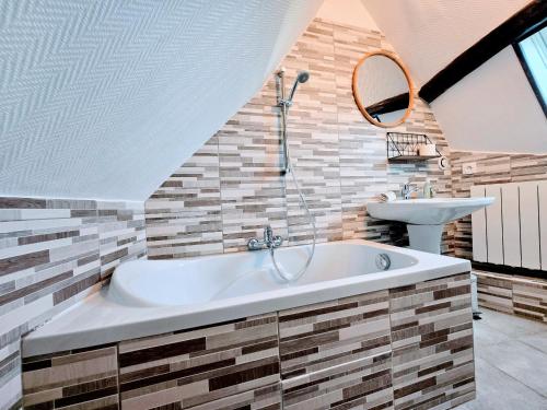 a bathroom with a tub and a sink at La Croix Duplex - Bail Partner in Chablis