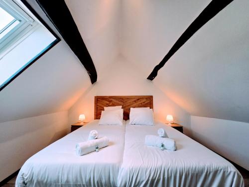 a bedroom with two towels on a bed at La Croix Duplex - Bail Partner in Chablis