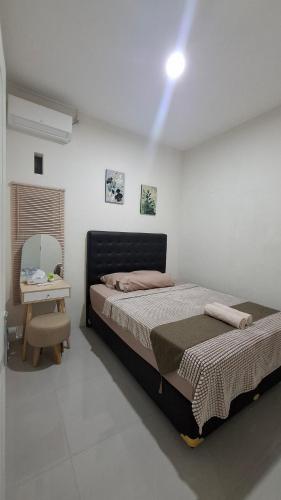 a bedroom with a bed and a table with a chair at Z Guest House in Banyuwangi