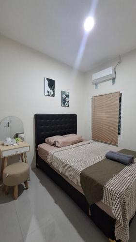a bedroom with a bed and a table with a chair at Z Guest House in Banyuwangi