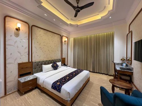 a hotel room with a bed and a desk and a desk at Hotel Virasat-E-Bushahr in Rāmpur