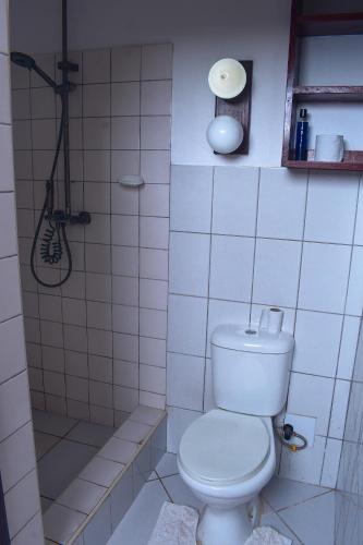 a white tiled bathroom with a toilet and a shower at Horizon Bavaria Villa in Mtwapa