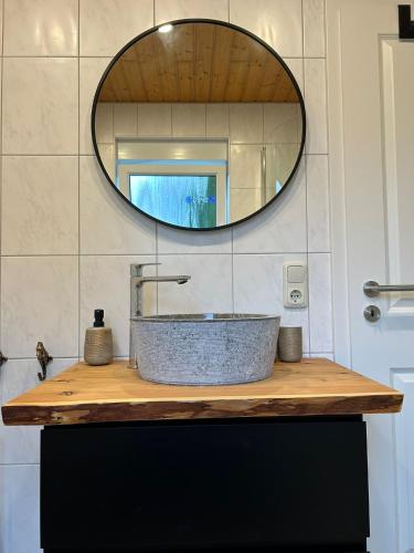 a bathroom with a stone sink and a mirror at ZweiundMeer Bungalow 2 in Wiek auf Rügen