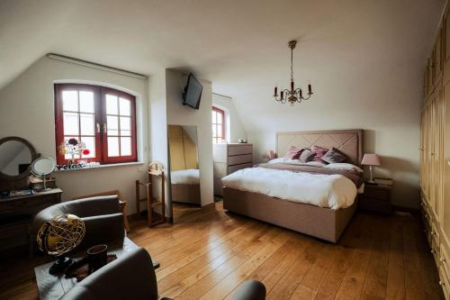a bedroom with a bed and a chair and a couch at Rozerie BV in Waregem