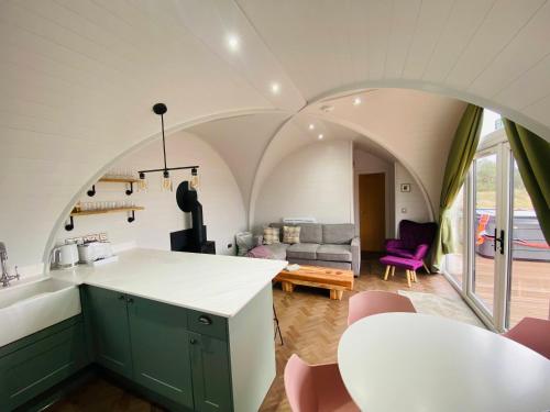 a kitchen and living room with an arched ceiling at Dornoch Pods in Dornoch