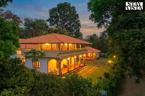 a house in the middle of a forest at night at Three Rivers by VEO - Part of StayVista in Jambur