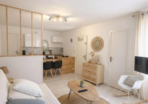 a living room and kitchen with a couch and a table at La Perle de la Baie - Plages à pied & Hyper centre in Pornichet