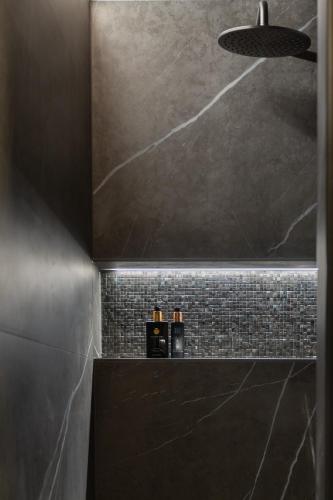 a bathroom with a black and gray tiled wall at Park Lofts Groningen in Groningen