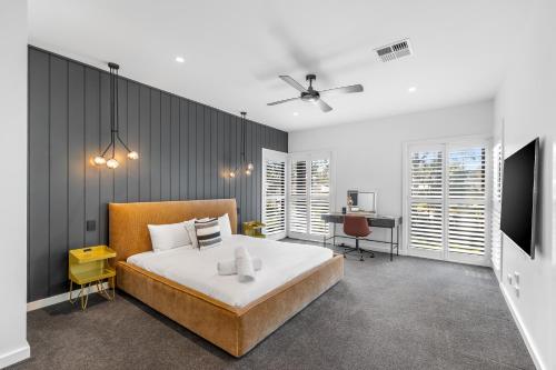 a bedroom with a large bed and a desk at Jacaranda Amber The Vintage Golfside Luxe Villa Hunter Valley in Pokolbin