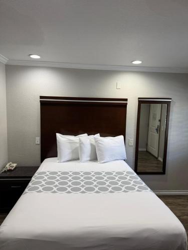 a large bed in a hotel room with a mirror at Rodeway Inn National City San Diego South in National City