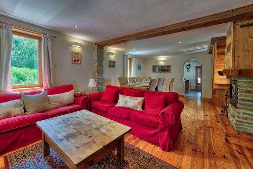Chalet Heidi في شامونيه مون بلان: غرفة معيشة بها أريكة حمراء وطاولة