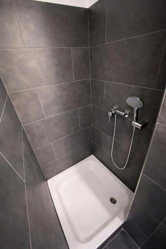 eine Dusche mit einer weißen Badewanne in einem Badezimmer in der Unterkunft Zzzimple in Pillig