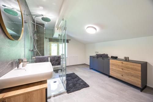 a bathroom with a sink and a glass shower at Schusterhäusl in Rauris
