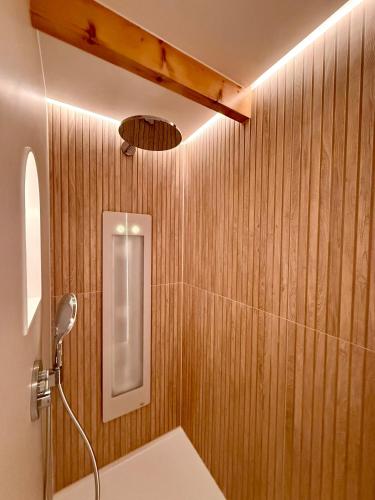 a bathroom with a shower with wood paneled walls at Sfeervol Tiny House met luxe jacuzzi & tuinkamer in Heerenveen