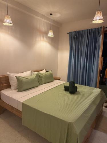 a bedroom with a large bed with green sheets and pillows at Sea Station in Habaraduwa Central