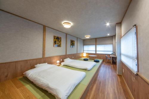 a bedroom with a large bed with white sheets at MONTIS HOTEL Hida Takayama in Takayama