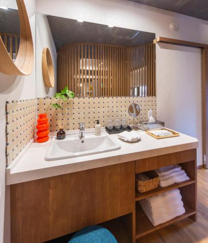 a bathroom with a sink and a mirror at MONTIS HOTEL Hida Takayama in Takayama