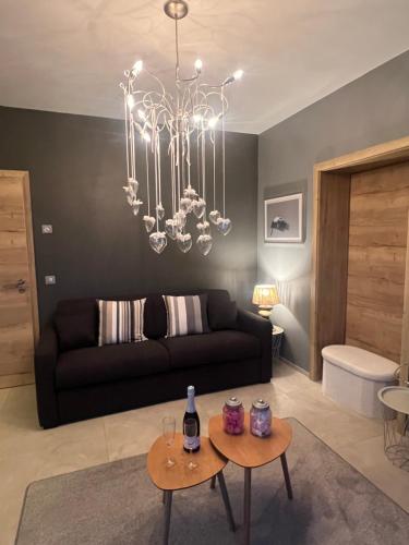 a living room with a black couch and a chandelier at Schlof'zheim in Friesenheim