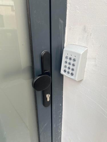 a lock on a door with a remote control at Lyon Cité Internationale - Loft Industriel Neuf in Caluire-et-Cuire