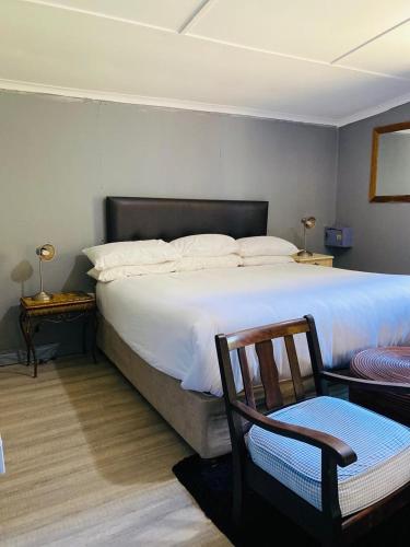 a bedroom with a large bed and a chair at Lavender farm home in Port St. Johns