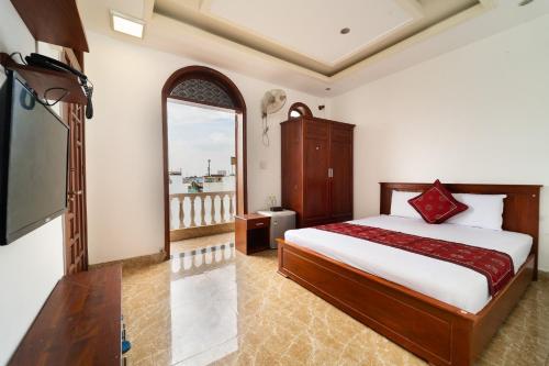 a bedroom with a bed and a large window at Collection O Long Phung Hotel in Ho Chi Minh City