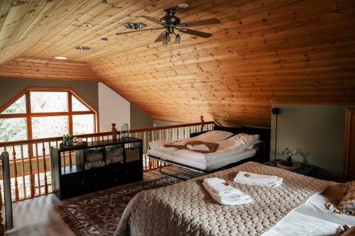 two beds in a room with a wooden ceiling at Villa Granliden in Ludvigsborg