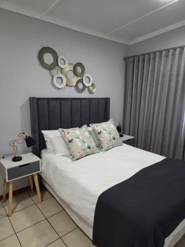 a bedroom with a bed with white sheets and pillows at Roux Casa 2 in Swellendam