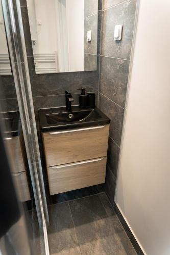 a bathroom with a black sink and a mirror at 201- Appartement- proche gare in Saint-Brieuc